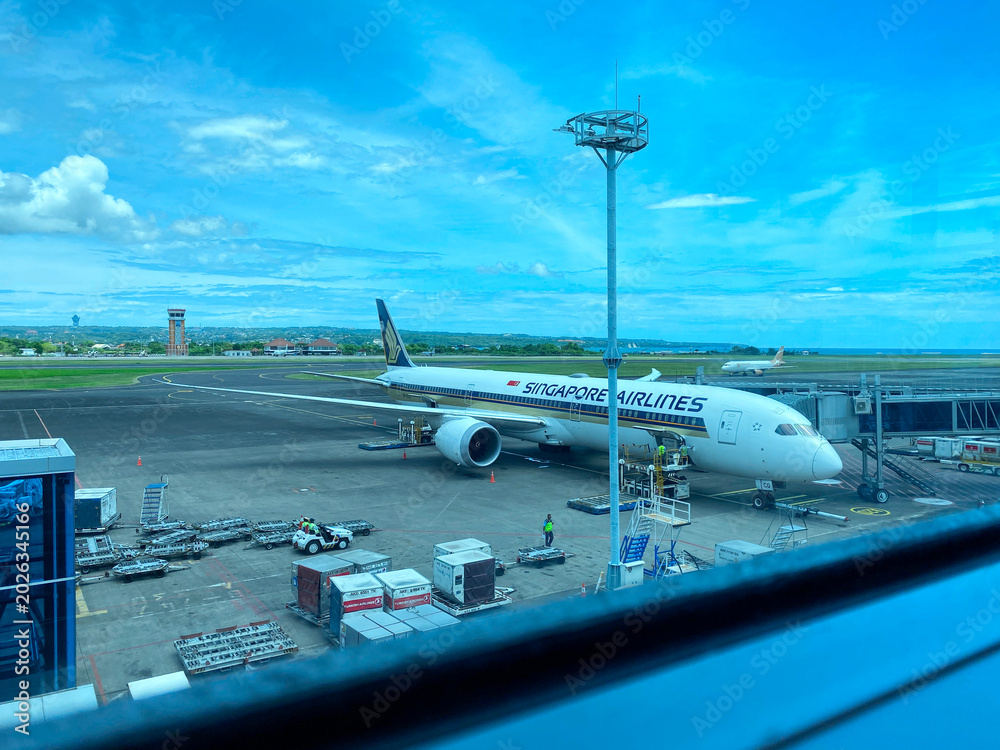 Fototapeta premium Singapore Airlines Boeing 787-10 Dreamliner parked at Gate 6 of Ngurah Rai International Airport for passenger boarding and ground handling - Bali, Indonesia, April 04, 2023