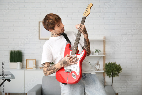 Cool tattooed young man pla...