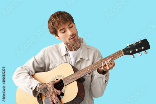 Cool tattooed young man pla...