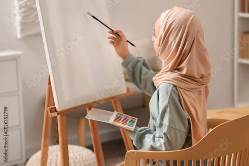 Foto Little Muslim girl in hijab painting at home