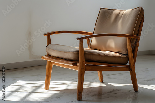 Comfortable wooden armchair with beige cushions in sunlit room.