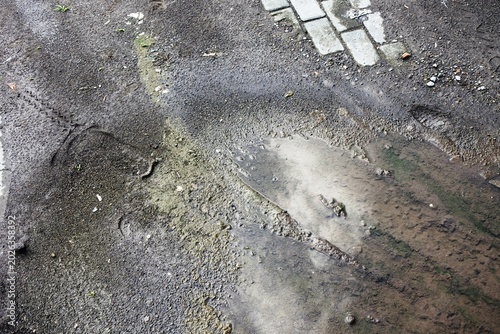 The reflection of cloud cover on the surface of a mud puddle in an outdoor area