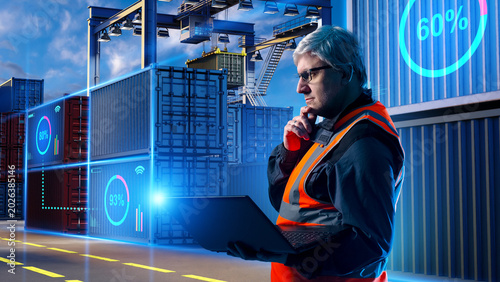 Smart logistics, Container tracking. Port operator monitors shipping containers with laptop and digital cargo data at automated terminal yard.