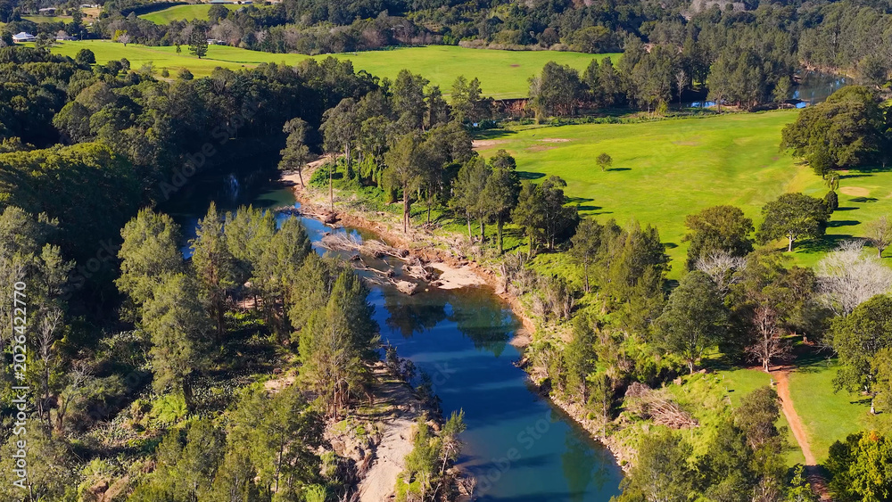 Fototapeta premium Aerial View of a Winding River Through Lush Green Valley in Australia