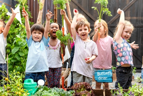 Fotografie Joyful children gardening together outdoors.
