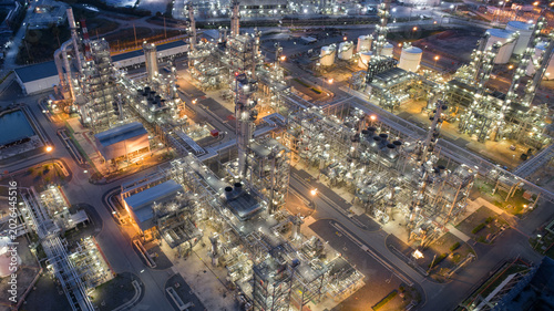 Bild auf Leinwand Nighttime Industrial Complex: An expansive petrochemical plant glows with artificial light under the night sky, showcasing a sprawling network of towers, tanks, and piping