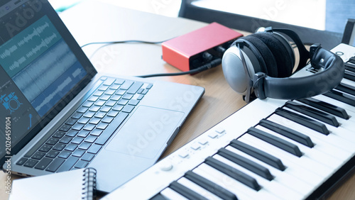Canvastavla Home studio setup with laptop showing audio tracks, MIDI keyboard, headphones and audio interface for songwriting and music production