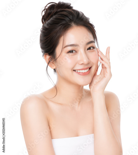 Glowing Beauty: A radiant young woman with flawless skin and a warm smile gently touches her cheek, embodying natural beauty and confidence.