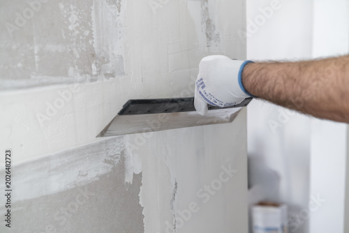 Konstfotografi Applying joint compound to drywall using a stainless steel trowel during finishing procedures