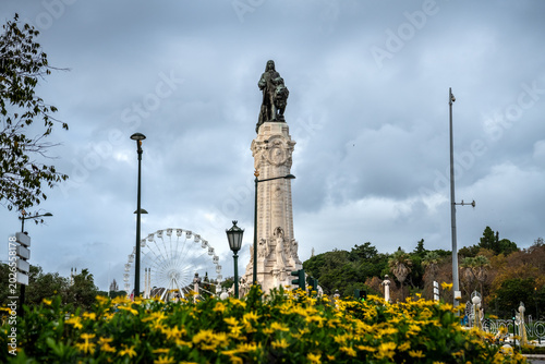 Quadro su tela Monument to the Marquis of Pombal Rising Above Flowers on a Cloudy Day in Lisbon