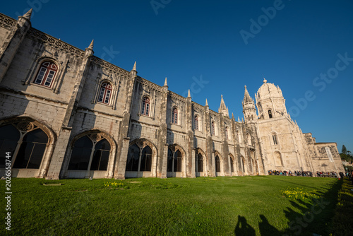 Photos Jerónimos Monastery Cloister Facade Under Clear Blue Sky in Belém, Lisbon, Portu