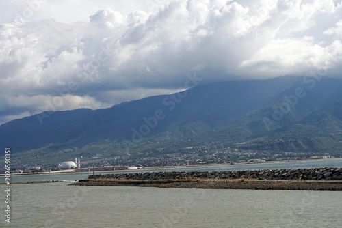 Φωτογραφία Distant mountains loom under heavy, drifting clouds