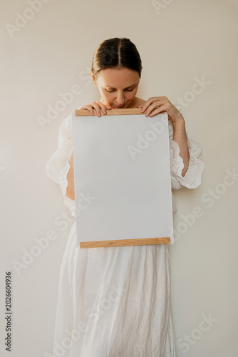 Woman Wearing Vintage White Clothes Holding Empty Framed Canvas