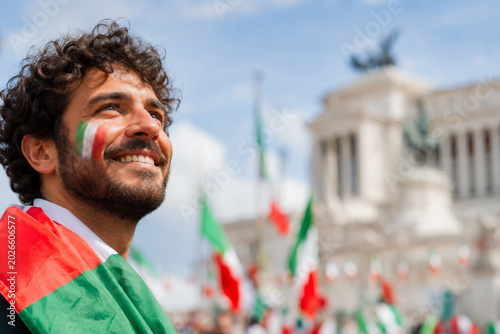 Man with Italian flag face paint celebrating Republic Day in Rome looking up.