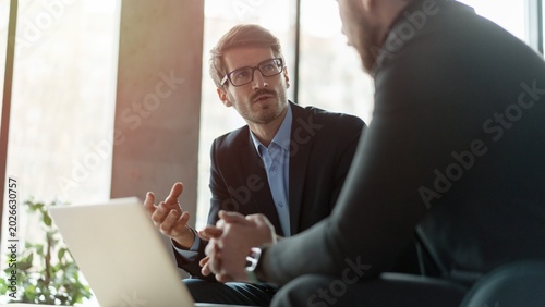 Businessmen discussing deal, sharing startup ideas, business partners negotiations or job interview in modern office