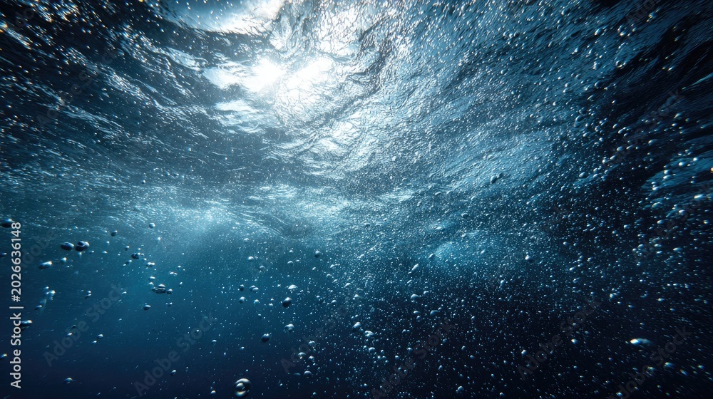 Fototapeta premium Underwater View of Sunlight Filtering Through Rippling Water Surface with Bubbles.