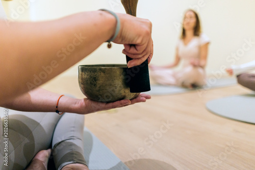 Fotografie Person playing ancient singing bowl in sound meditation session