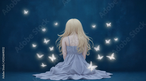 A young woman with long blonde hair, seen from behind, sits gracefully in a flowing lavender dress against a deep blue, textured backdrop. She is surrounded by numerous glowing white butterflies that 
