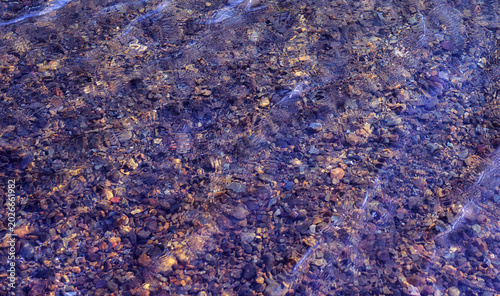 Canvas Print Colorful pebbles under water surface.