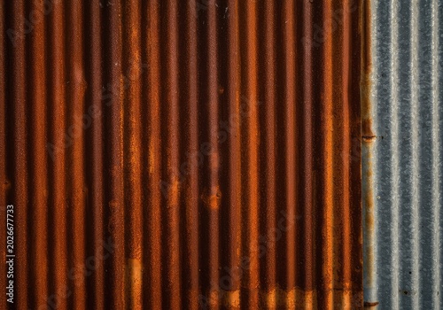Heavily oxidized metal siding of an old forgotten barn, showcasing deep orange and brown corrosion textures under soft light ,patina ,vintage ,decay