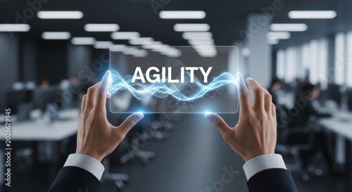 Businessman holding virtual glass screen with word agility glowing blue energy waves, for corporate flexibility, rapid adaptation, strategic business growth success
