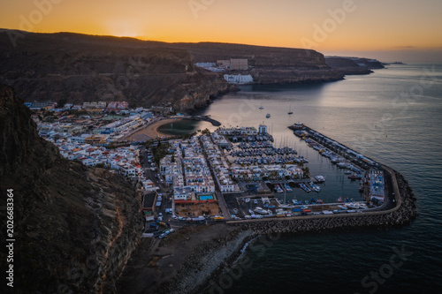 Puerto de Mogan with the beach in Gran Canaria, Spain at sunrise. Favorite vacation place for tourists and locals on island. Harbor in Puerto de Mogan and Playa Mogan on Grand Canary Island. March