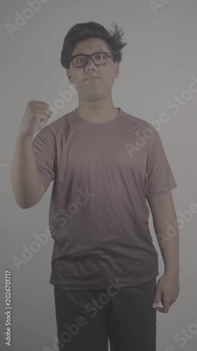 Southeast Asian person wearing brown jersey, raised his clenched fist in excitement S-Log3, S-Gamut3.Cine