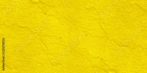 Foto Textured yellow background, representing a vibrant and sunny surface with a rough, uneven texture that suggests warmth and energy