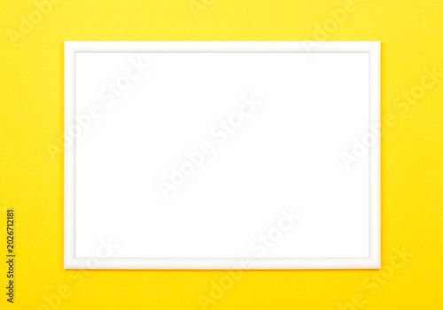 White picture frame on bright yellow background, flat lay.