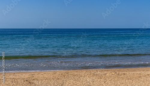Calm Mediterranean beach with golden sand and blue sea in northern Morocco
