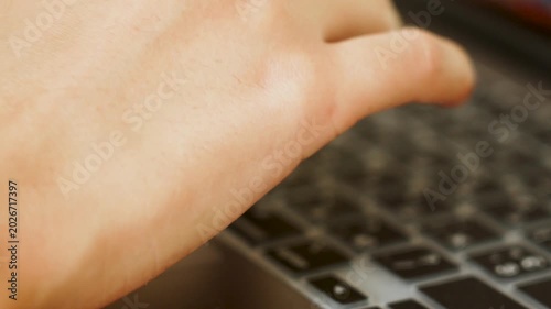 Fingers quickly typing on a modern laptop with dual language keyboard