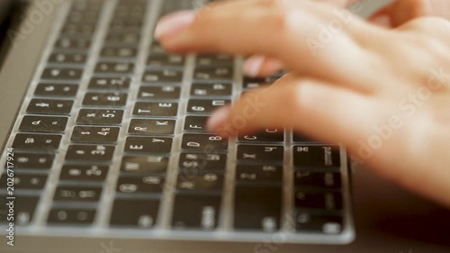 Woman's hands typing on laptop keyboard with Cyrillic layout