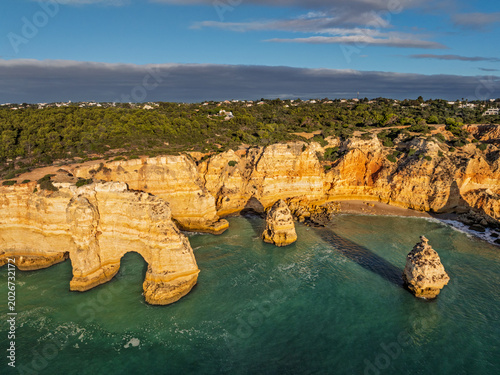 Aerial view of Praia da Marinha beach in Algarve, Portugal, with ocean cliffs, sea stacks and rocky shoreline.