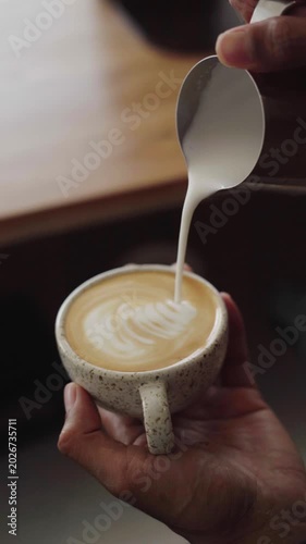 Professional barista making cappuccino in a modern coffee shop.