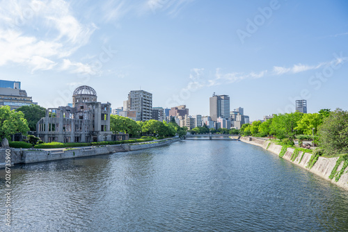 Fotografía Atomic Bomb Dome Against Blue Sky with Green Trees and Copy Space