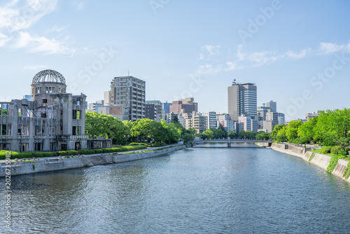 Fotografie Atomic Bomb Dome Against Blue Sky with Green Trees and Copy Space