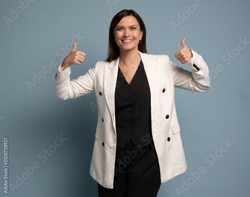 Middle-aged happy business woman shows thumb up