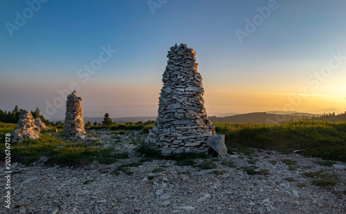 large mountain cairns along a trail  in a beautiful landscape during a sunset...
