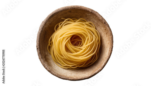 Quadro su tela Raw spaghetti nest in rustic earthenware bowl, isolated on transparent backgroun