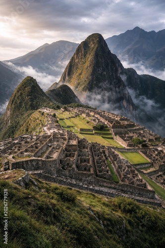 Breathtaking aerial view of Machu Picchu surrounded by misty mountains captures the mystery beauty and spirit of ancient Incan civilization.