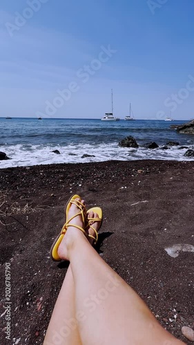 Woman relaxing on the famous red beach in santorini greece