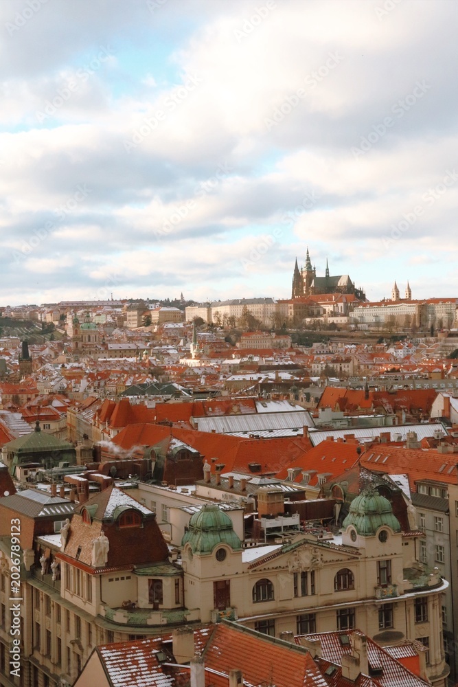 Obraz premium Panoramic view of Prague Castle rising above the river with bridges, historic rooftops