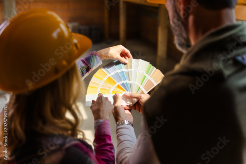 Couple Discuss Paint Colors in a Construction Site During the Afternoon in a Warehouse Setting