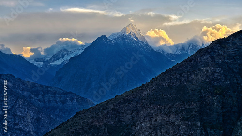 Slika na platnu Mountain shadow trail in Himachal Pradesh, India at sunset with dramatic light on Himalayan peaks and deep valley silhouettes, capturing cinematic high altitude landscape