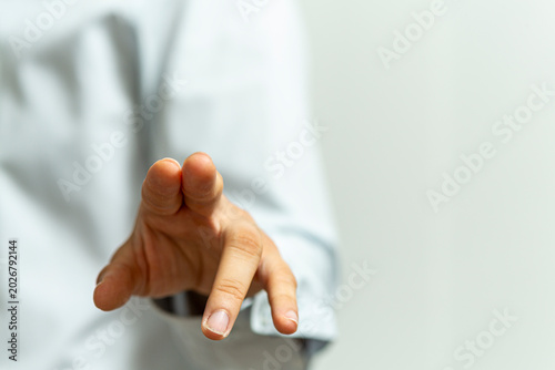 Close up of a person's hand reaching out, hinting at interaction or selection.  Touching concept.