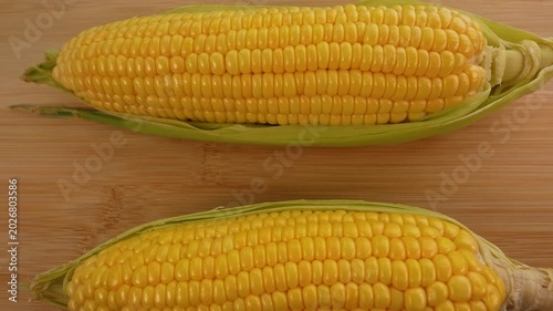 Fresh corn cob on wooden background top view.