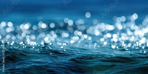 Gentle blue waves with bright sunlit sparkles on the surface