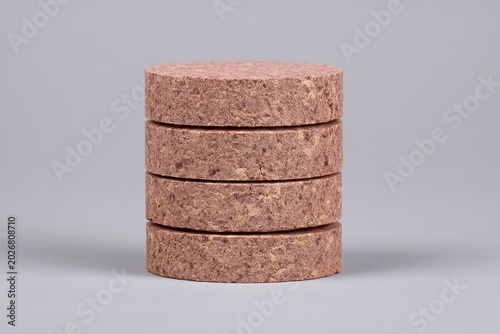 A stack of round cork coasters on a plain background