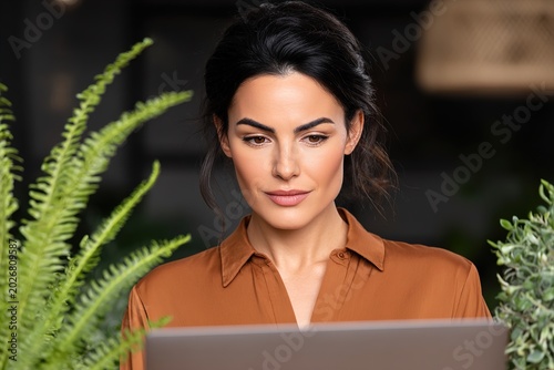 A focused woman working on her laptop in a serene environment