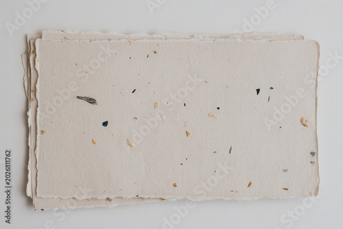 Natural mulberry paper sheets with recycled inclusions, eco-friendly and rustic for stationery, design, and mockups. Plant-based design.